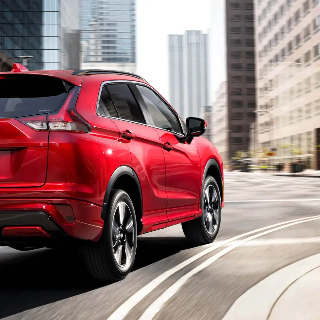Red 2023 / 2024 Mitsubishi Eclipse Cross Compact SUV driving on a city street