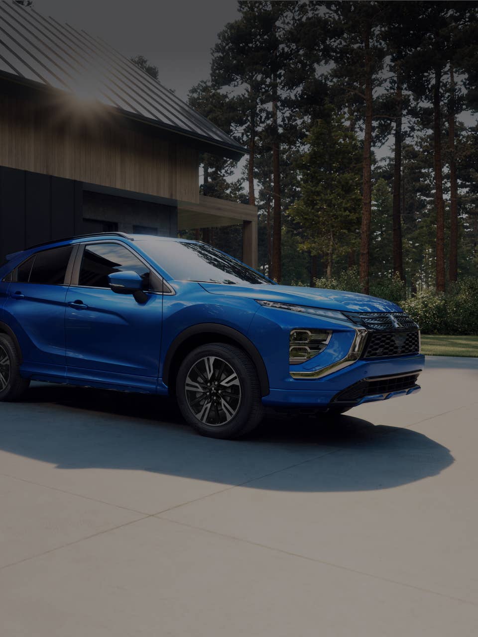 A blue 2024 / 2025 Mitsubishi Eclipse Cross Compact SUV parked in front of a house