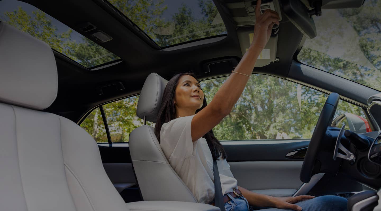 Driver adjusting the rearview mirror in the 2024 / 2025 Mitsubishi Eclipse Cross Compact SUV