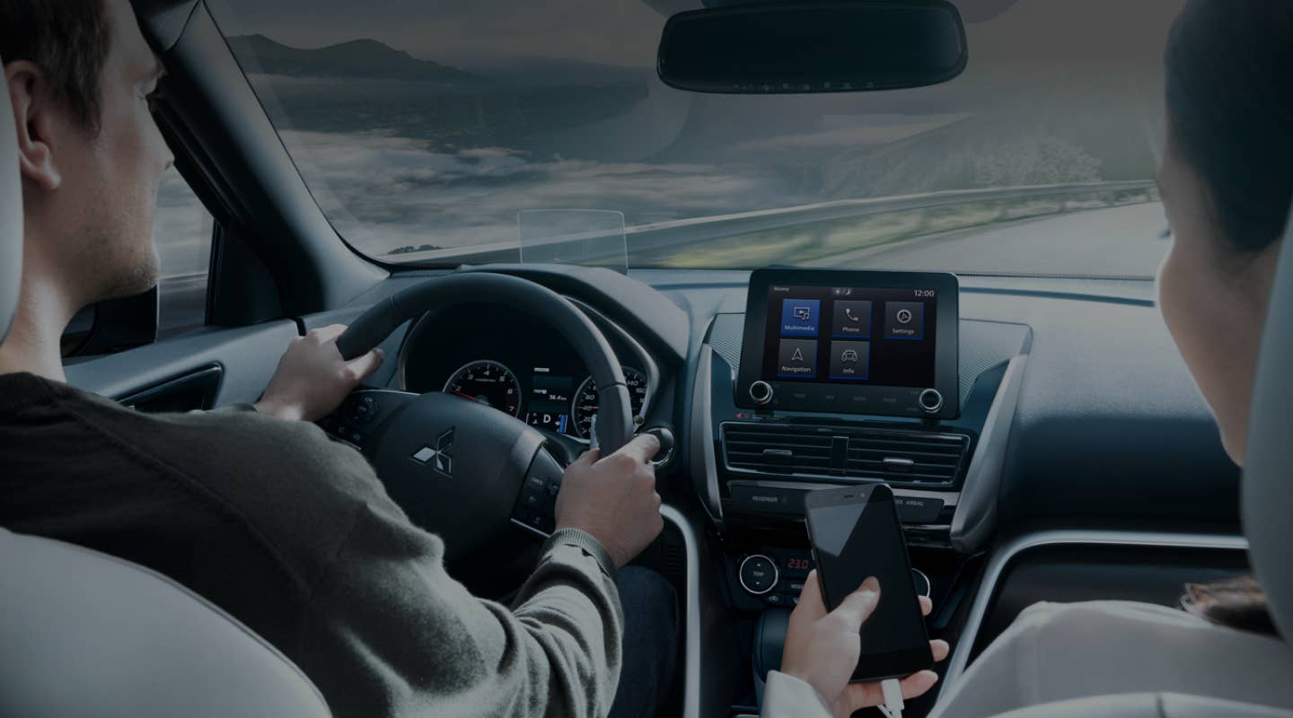Driver and passenger using the Connectivity features in the 2024 / 2025 Mitsubishi Eclipse Cross Compact SUV