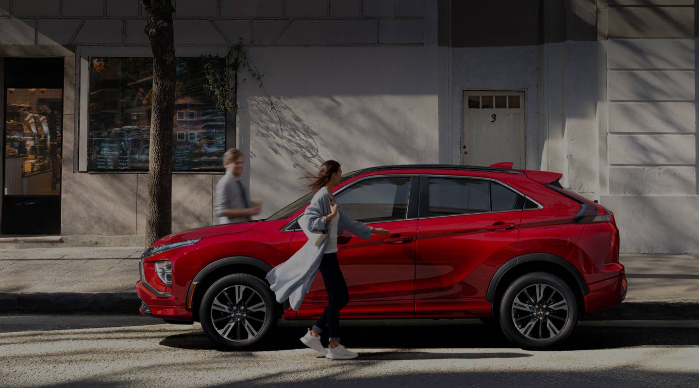 Side profile of a red 2024 / 2025 Mitsubishi Eclipse Cross Compact SUV parked