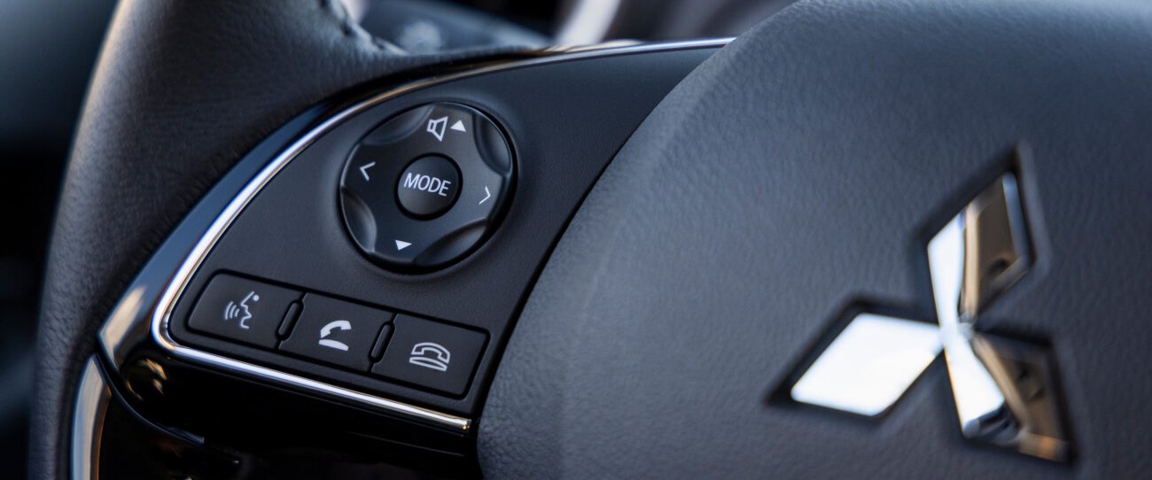 Close-up view of a 2023 Mitsubishi Mirage G4 sedan's steering wheel buttons