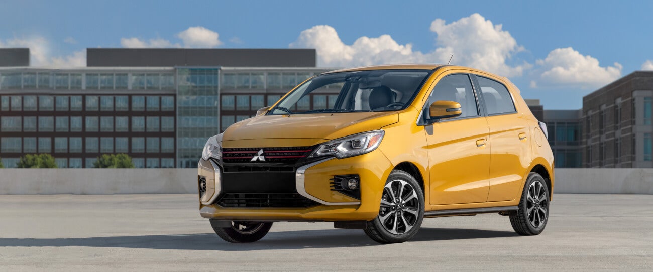 Front and side view of a parked sand yellow metallic 2022 & 2023 Mitsubishi Mirage