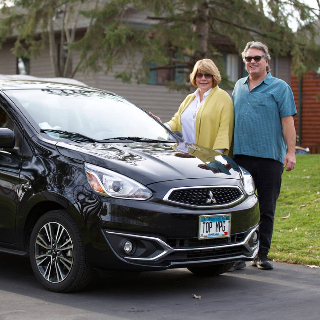 Couple standing in front of a black 2022 Mitsubishi Mirage 