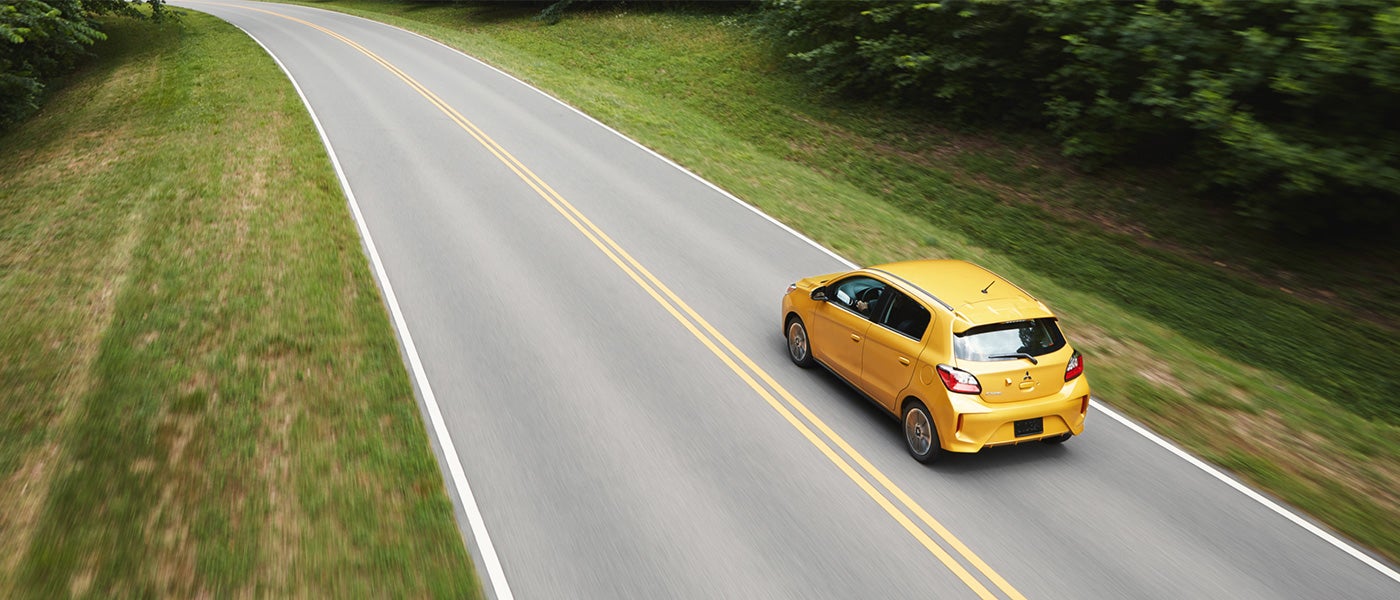 Woman placing flower pot and other items in the spacious cargo area in the 2023 Mitsubishi Mirage