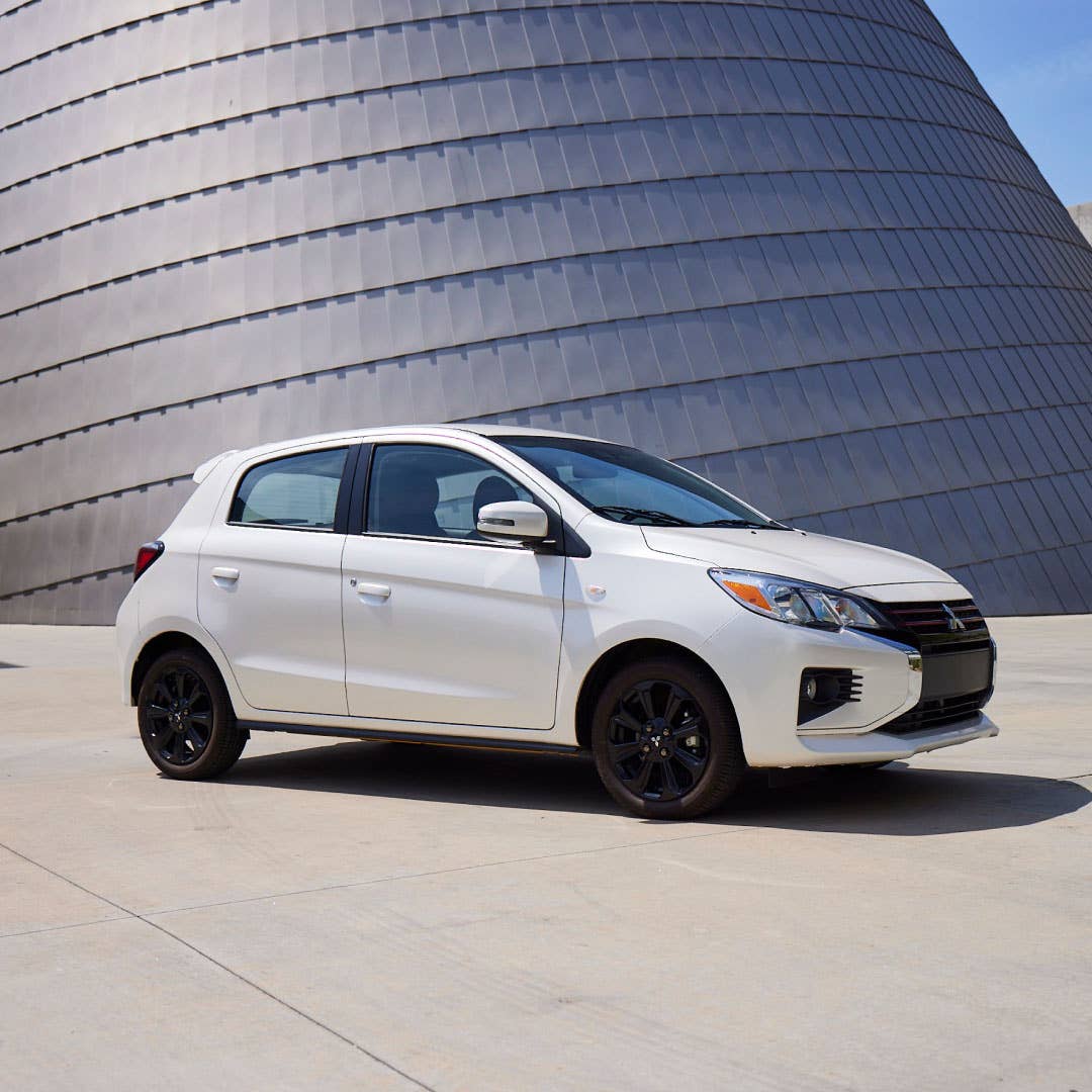 White 2024 Mitsubishi Mirage Compact Hatchback Compact Hatchback parked in front of a curved textured wall