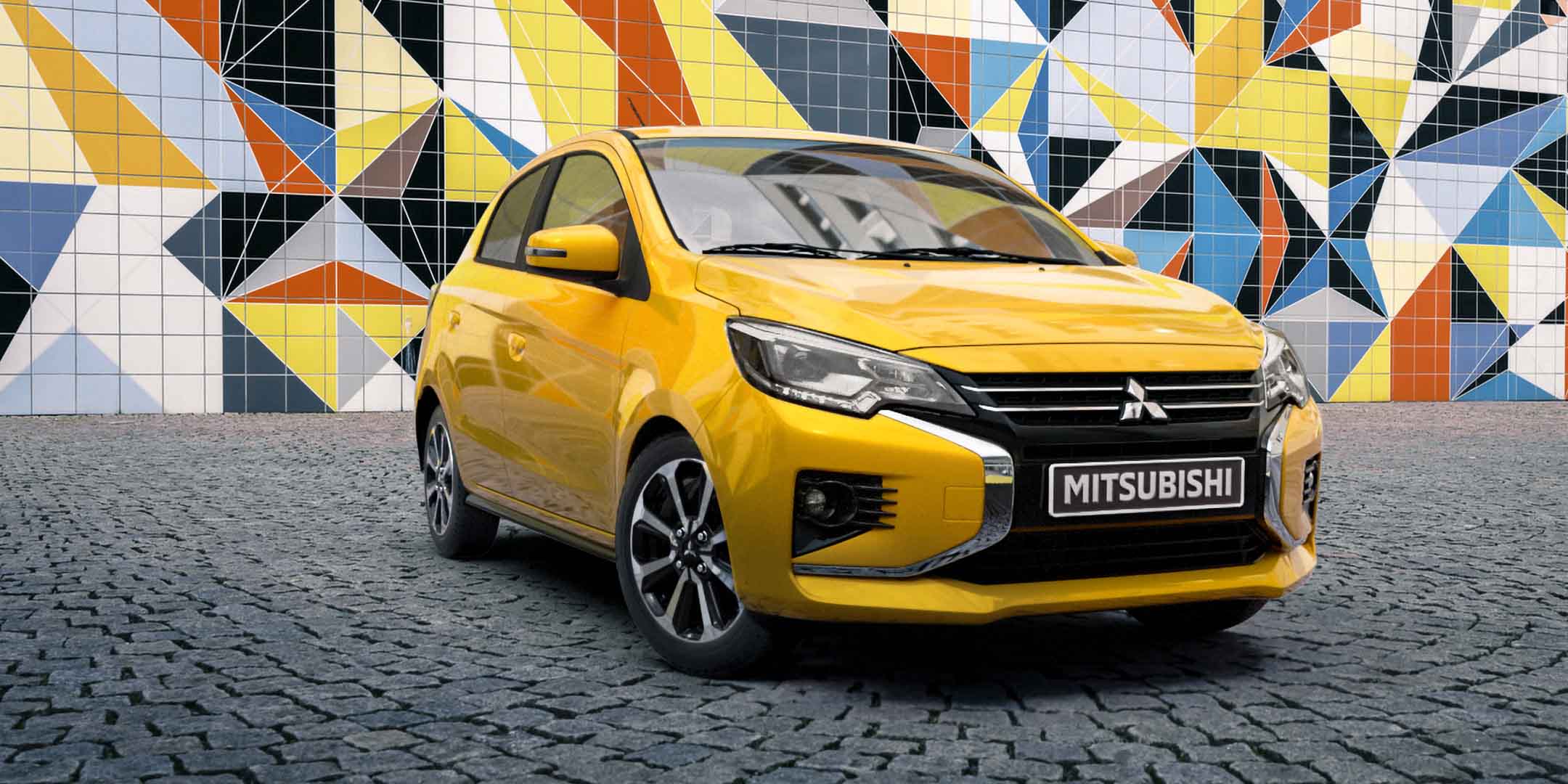 A yellow Mitsubishi Mirage parked.