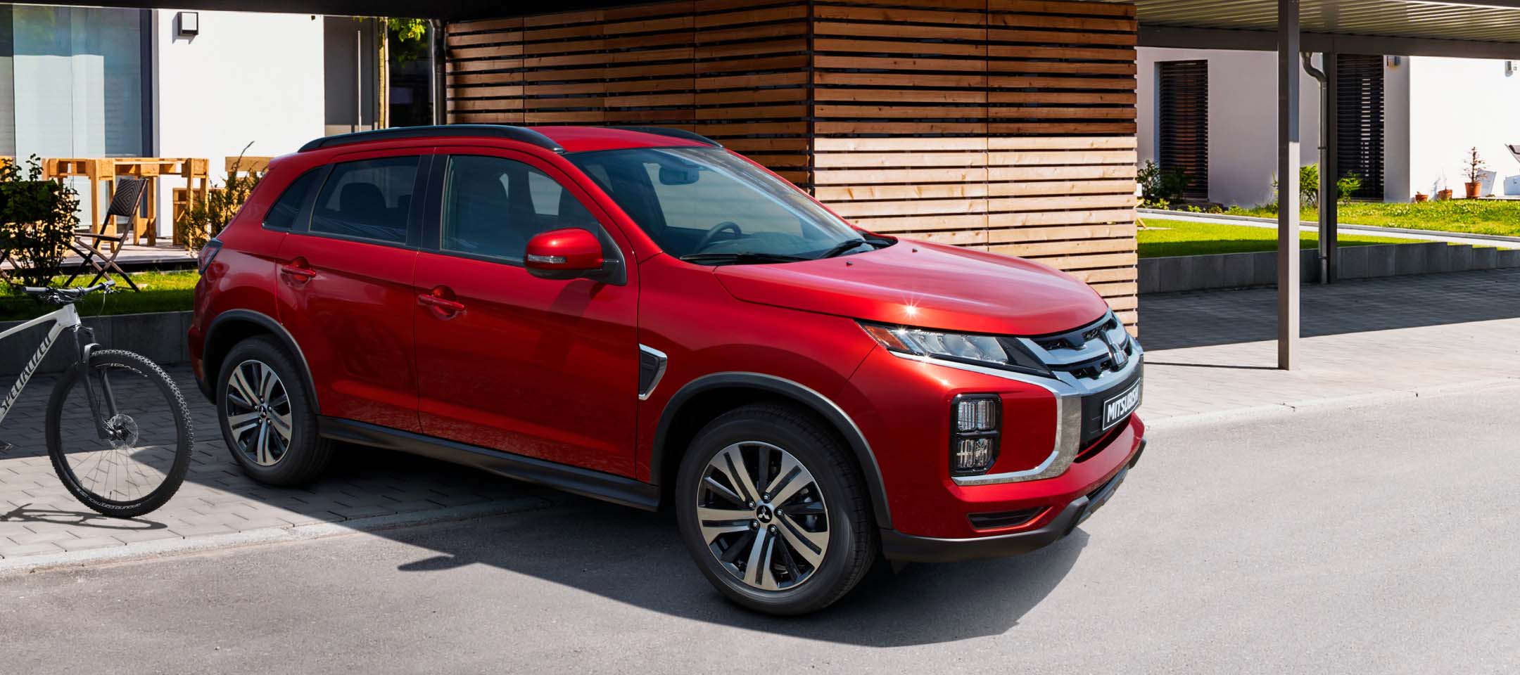 Angled view of a red 2023 Mitsubishi Outlander Sport SUV parked