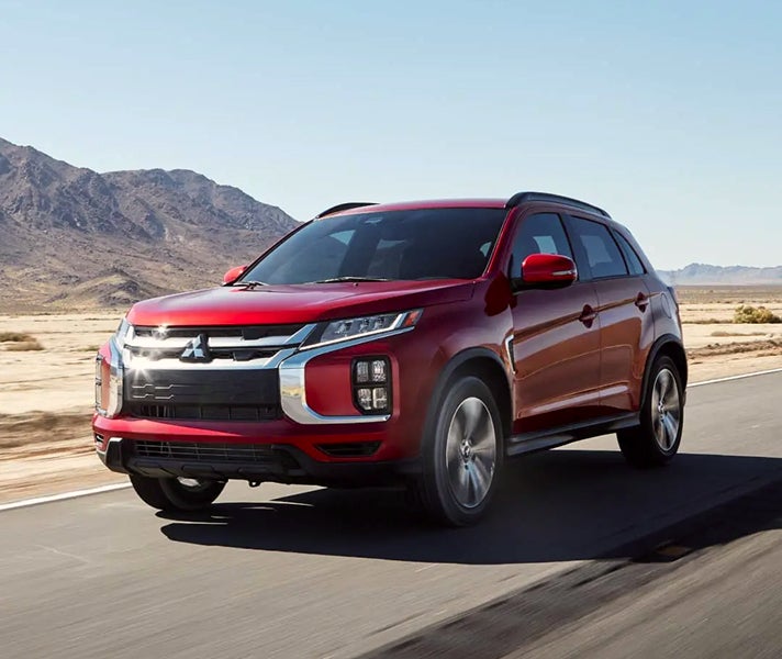 Red 2026 Mitsubishi Outlander Sport SUV driving on a desert road