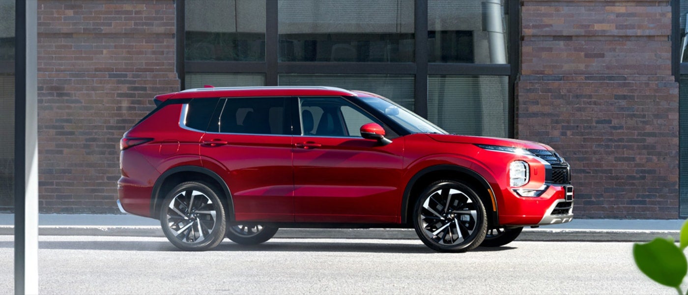 Side profile of a red diamond 2023 Mitsubishi Outlander SUV