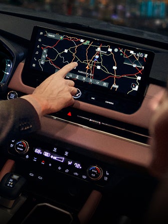 Close up on hand interacting with display on 2026 Mitsubishi Outlander SUV