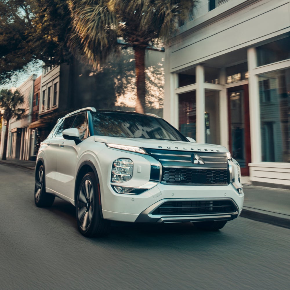 White 2026 Mitsubishi Outlander SUV driving on a road 