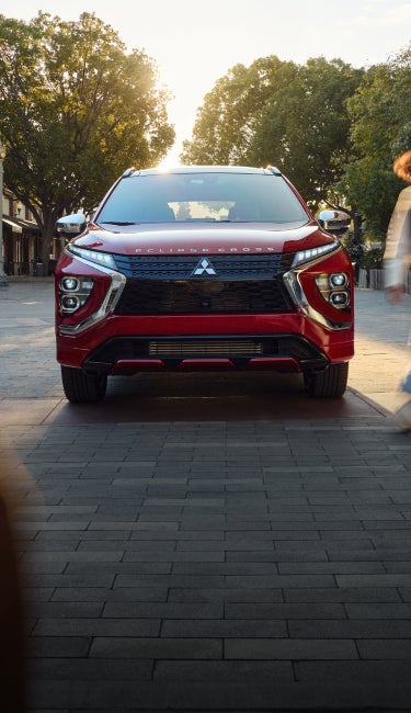 Front view of a red 2026 Mitsubishi Eclipse Cross compact SUV with blurry passenger