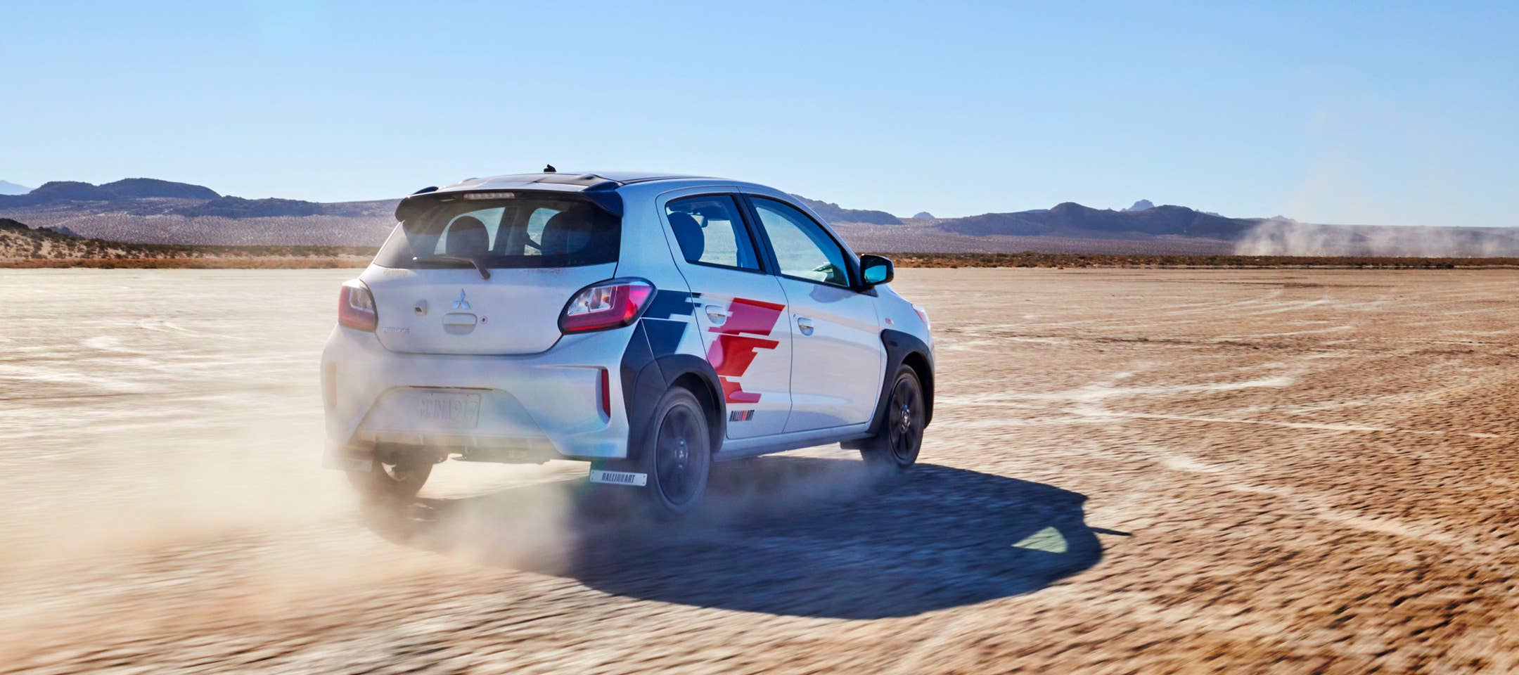 Angled back view of a 2023 Mitsubishi Ralliart Edition Mirage hatchback in the desert