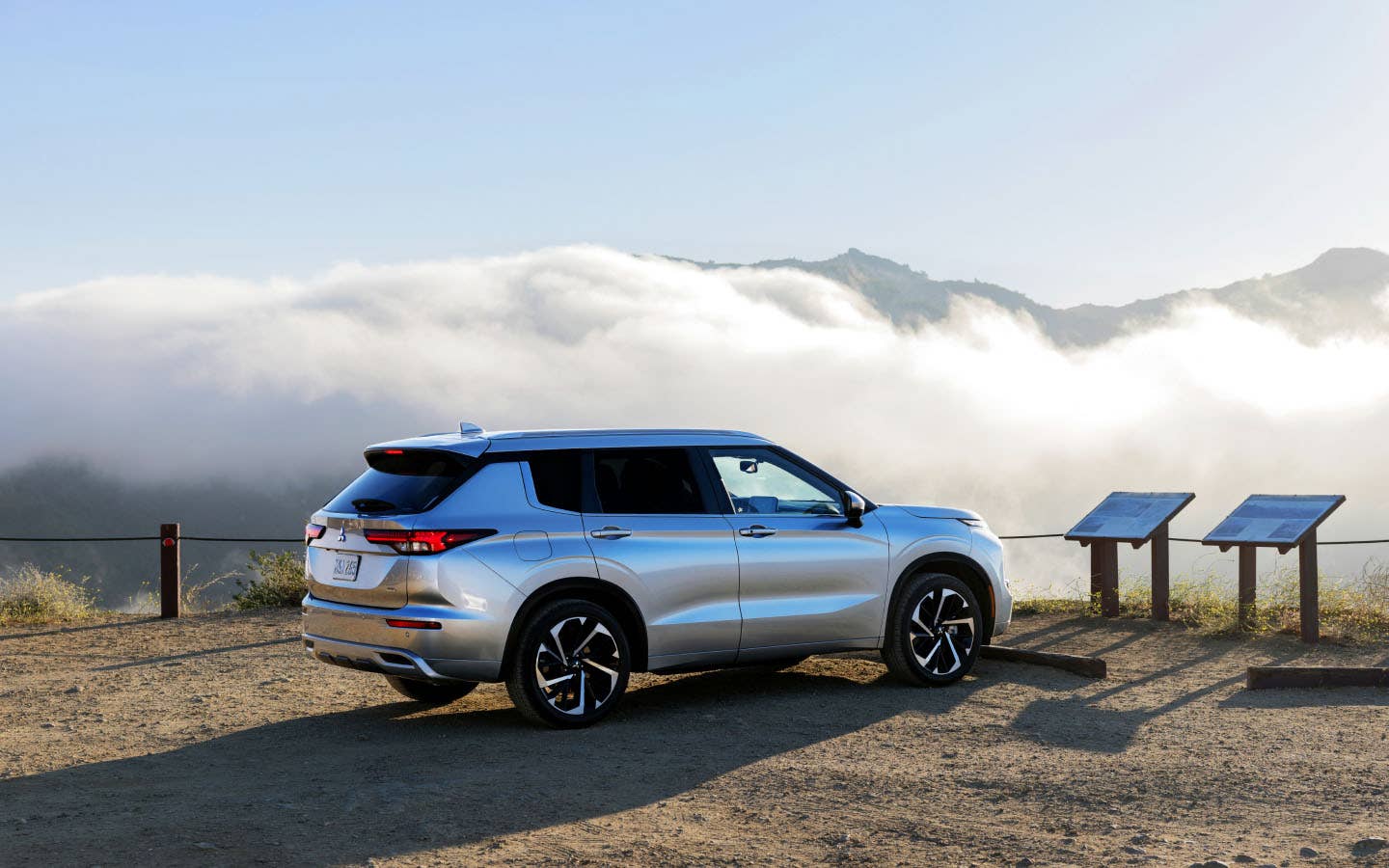 A silver 2023 Mitsubishi Outlander SUV waiting for Roadside Assistance service in the mountains